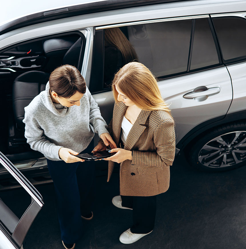 Two-women-conversing-near-a-parked-car