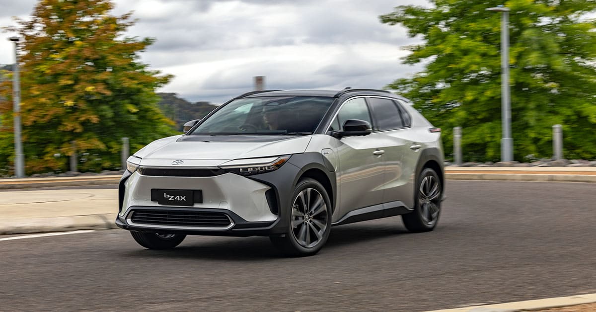 A 2021 Toyota Highlander drives along a scenic road, showcasing its sleek design and modern features.