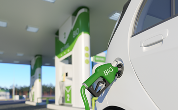 A green car is being charged at a gas station, showcasing an eco-friendly approach to refueling. globalblog'
