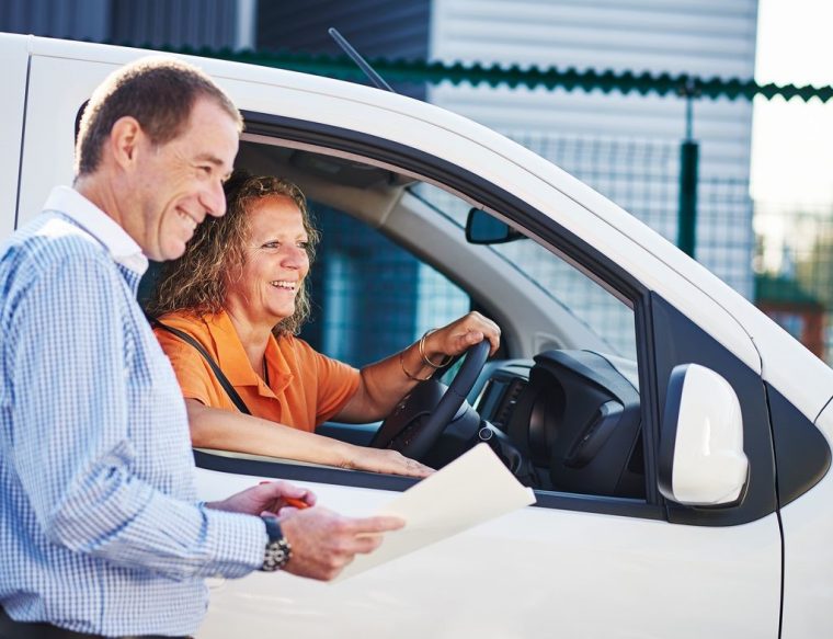 A man and woman are smiling together while seated inside a van, conveying a sense of joy and companionship. A man and woman are smiling together while seated inside a van, conveying a sense of joy and companionship.