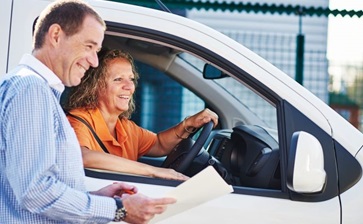 A man and woman are smiling together while seated inside a van, conveying a sense of joy and companionship. globalblog'