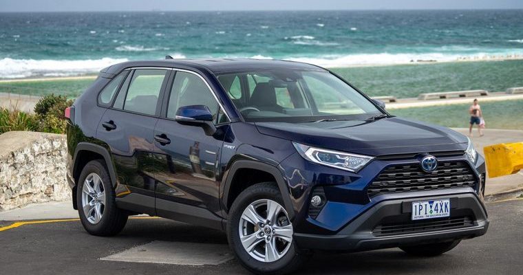 A Toyota RAV parked on the roadside, showcasing its sleek design and modern features in a natural setting.