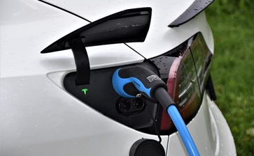 An electric car charging at a station, plugged into an electric charger for power. globalblog'