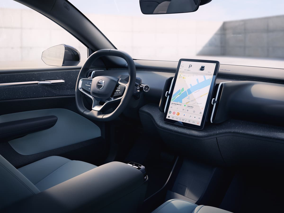 Interior view of a car featuring a steering wheel and a tablet mounted on the dashboard.