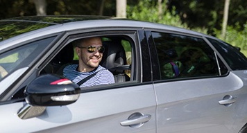 Smiling-Man-Sitting-in-Car-Looking-Out-of-Window