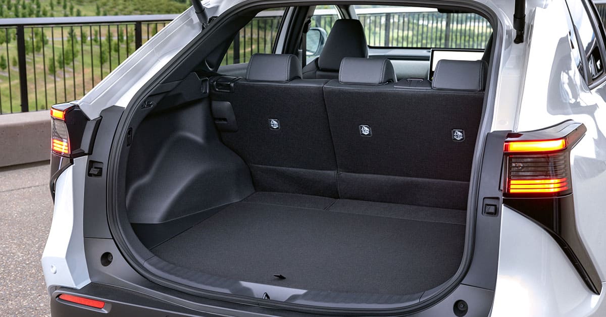 The trunk of a white SUV with the seats folded down, showcasing ample storage space and a clean interior.