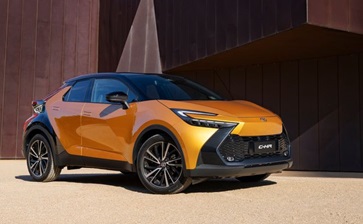Toyota C-HR SUV parked in front of a modern building, showcasing its sleek design and urban appeal. globalblog'