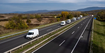 A large number of minivans move along the highway