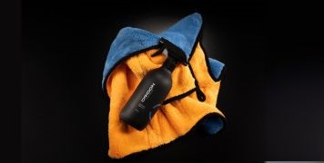 Flay lay of Oridon premium ceramic sealant spray bottle and orange buffing cloth.