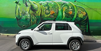 Hyundai INSTER in white parked in front of an urban mural