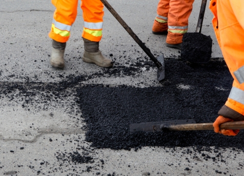 highway workers resurface a road