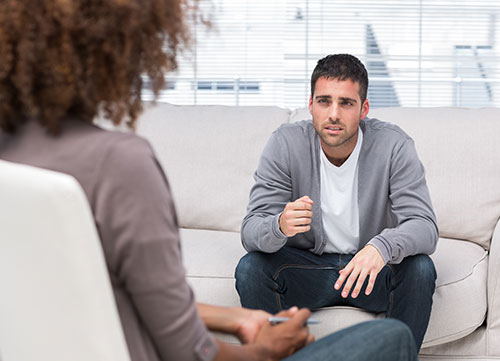 Man speaking to a therapist while she is listening to him attentively