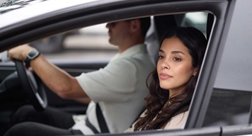EV_Day_Couple_Driving_3-medium Two people driving in a vehicle