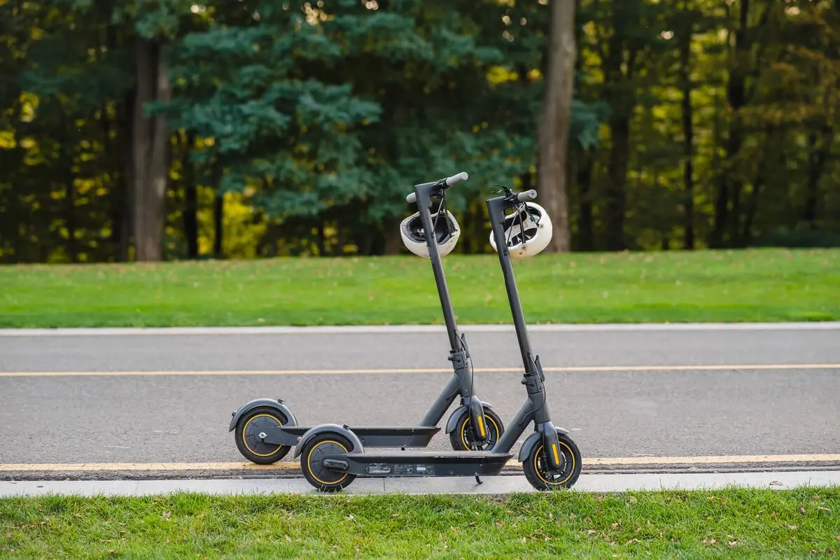Two scooters with helmets on the footpath