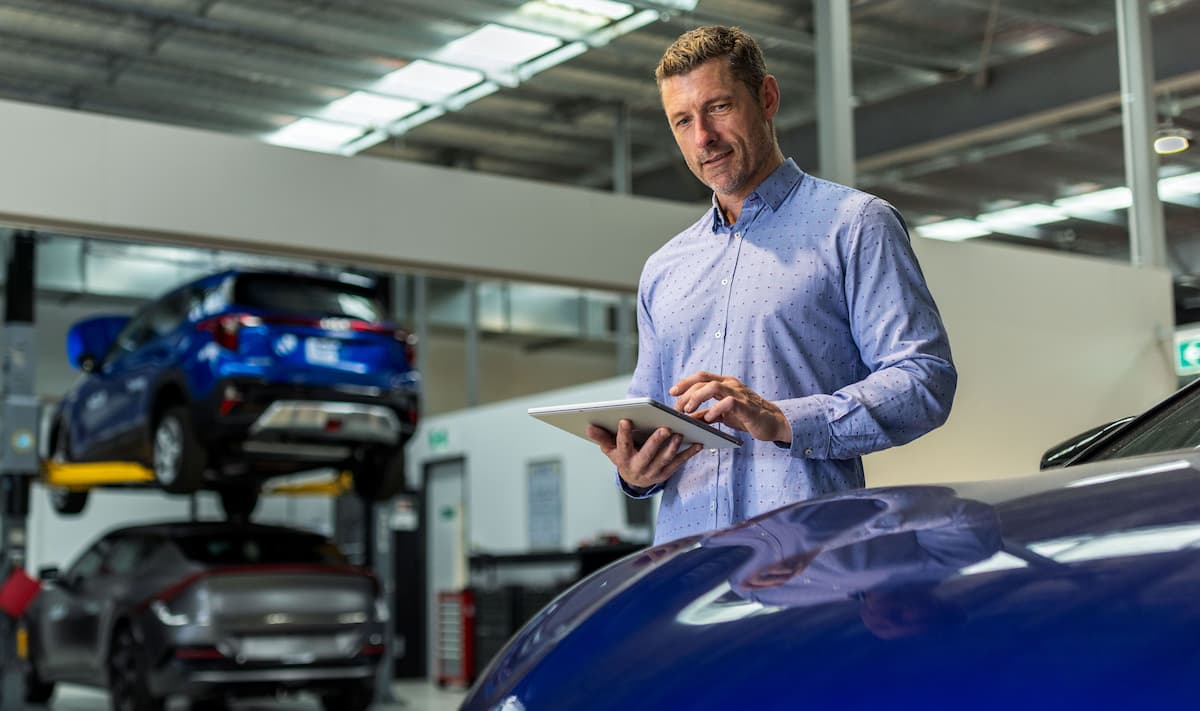Person using a tablet in an automotive workshop Person using a tablet in an automotive workshop