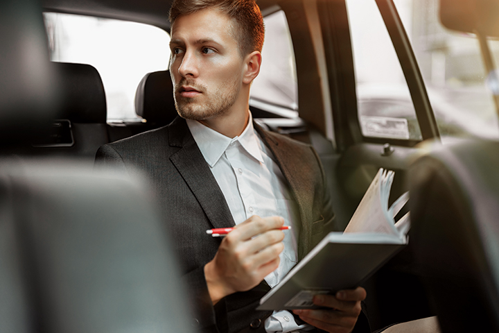 SGF_Onward_People_RGB_LR_10 Man writing in a notebook in the back seat of a vehicle