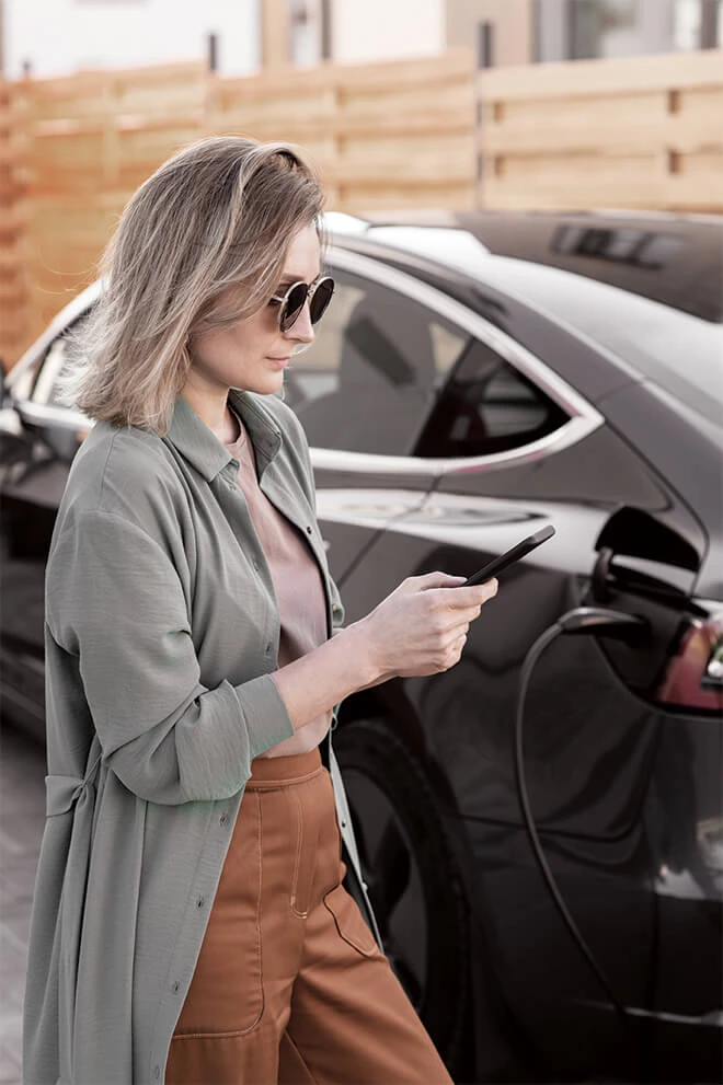 Woman on phone in front of vehicle