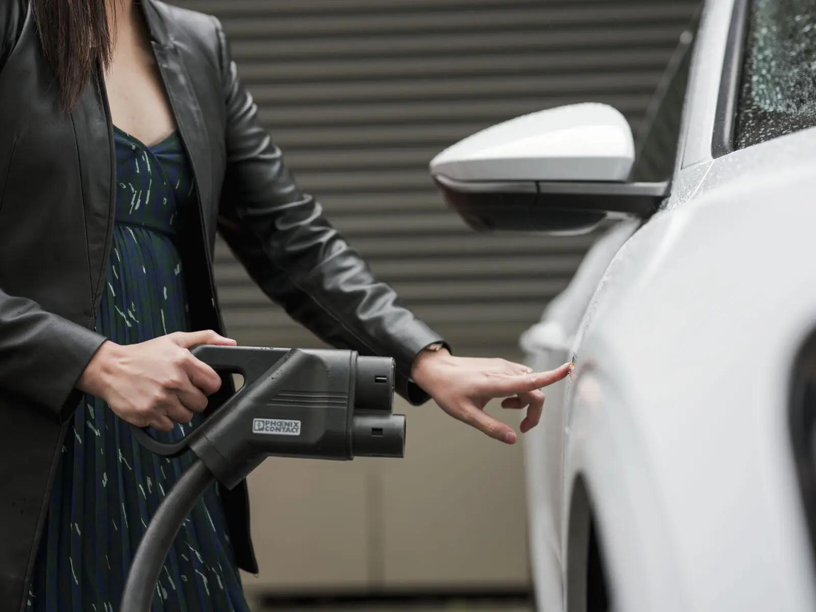 Woman plugging in EV charging cable