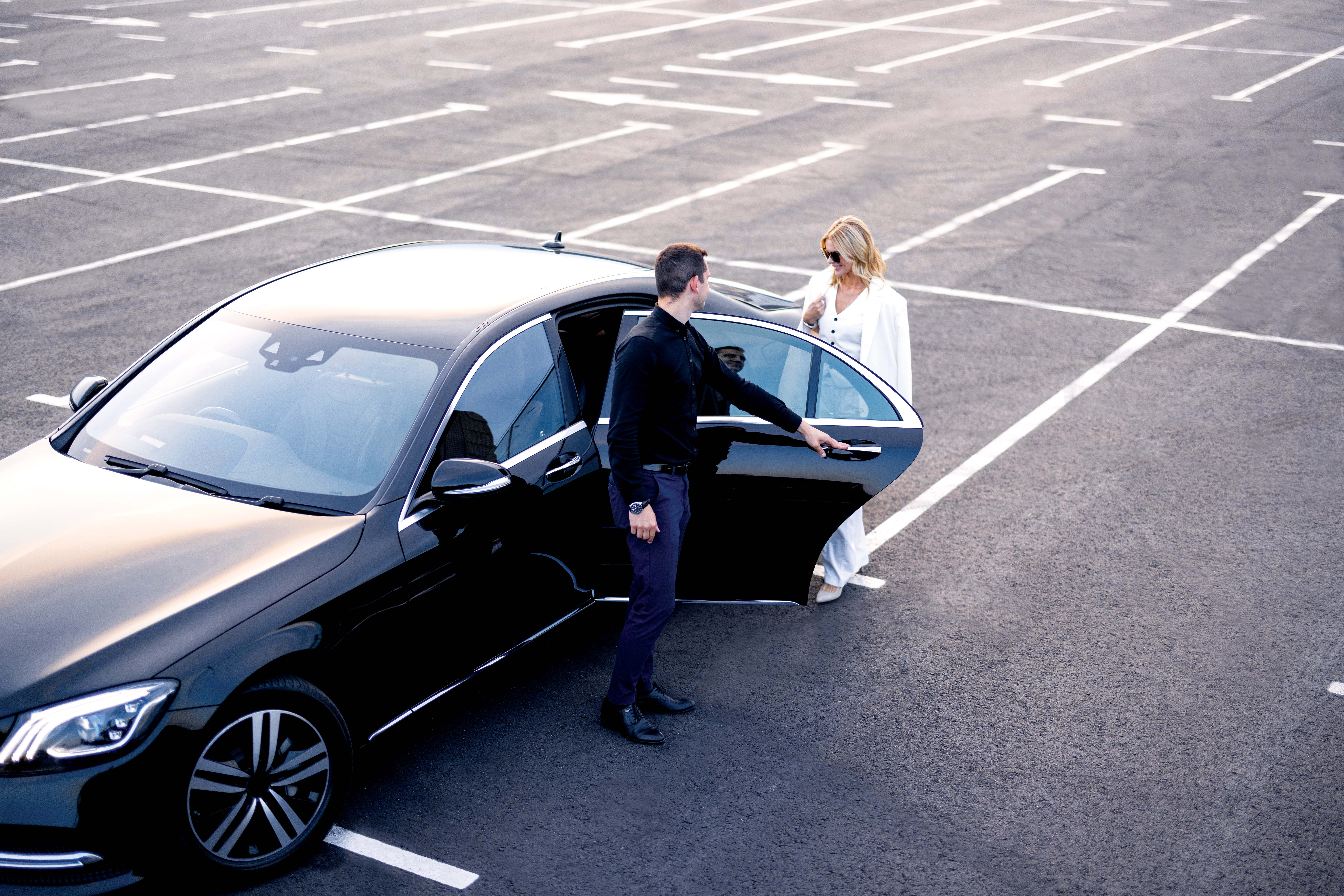 Man-Opening-Car-Door-For-Woman-In-Car-Park