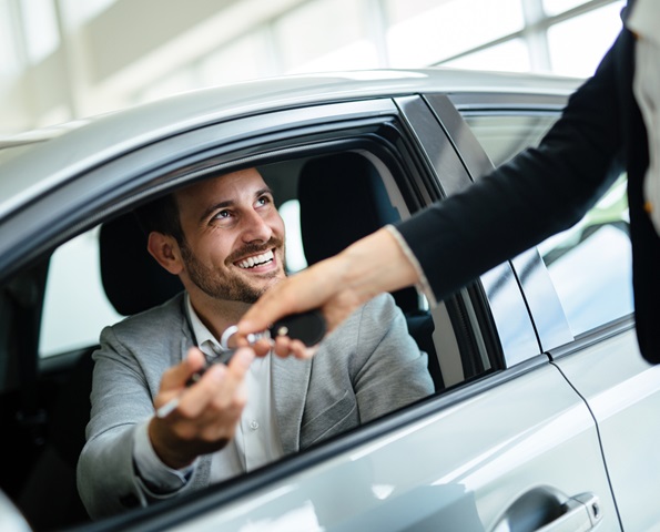 salesperson-handing-over-keys-to-happy-driver