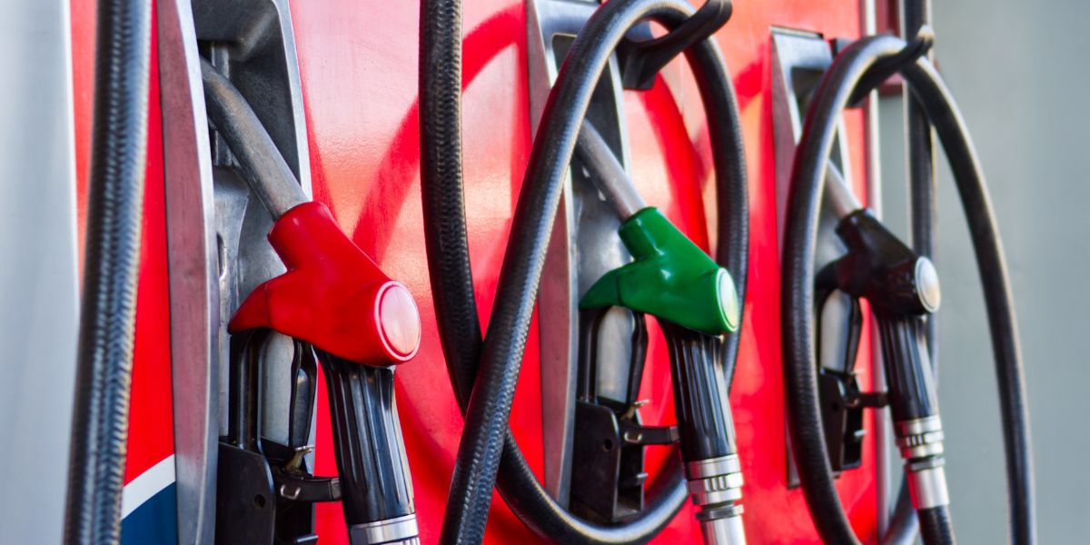 autumn budget 2026 company car tax changes: A close-up of red, green and black fuel nozzles hanging in their holsters on a red petrol pump.