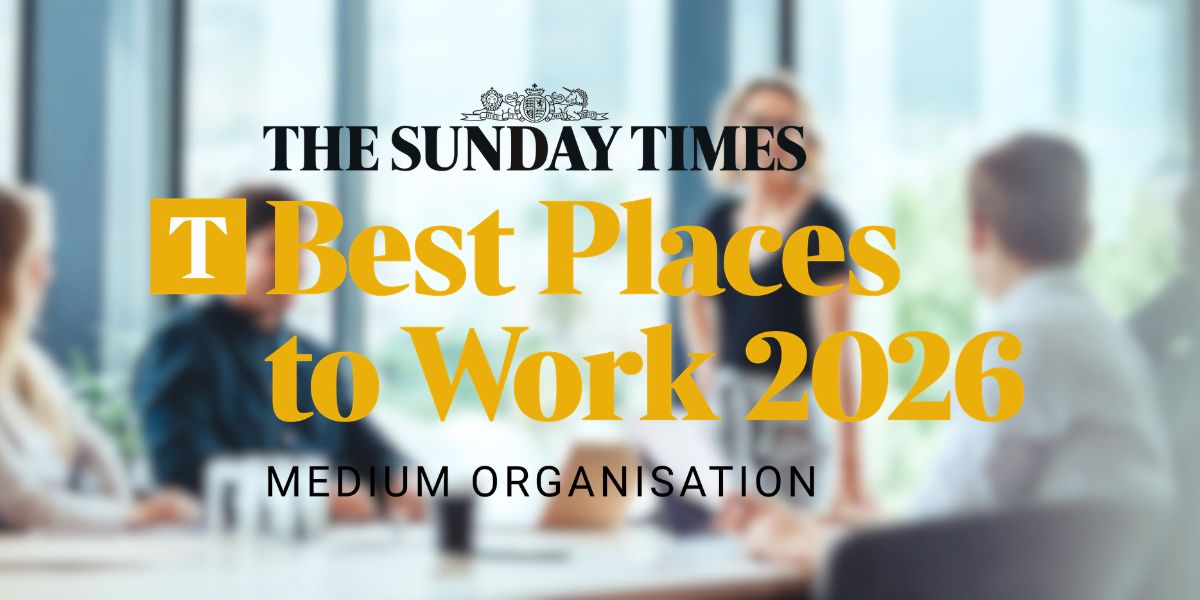 sunday times best places to work: The Sunday Times Best Places to Work 2026 – Medium Organisation award logo, overlaid on a blurred background of a workplace meeting.