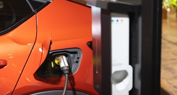 used-ev-leasing-featured-image image of orange electric car being charged